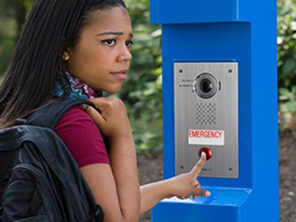 young woman using intercom systems to alert an emergency