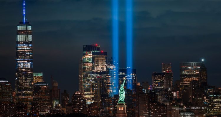 Tribute In Light Remembers The September 11 Terrorist Attacks With Statue Of Liberty In Foreground.