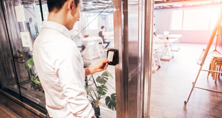 An Employee Uses An Access Control System, An Essential Part Of A Fully Integrated Security System.