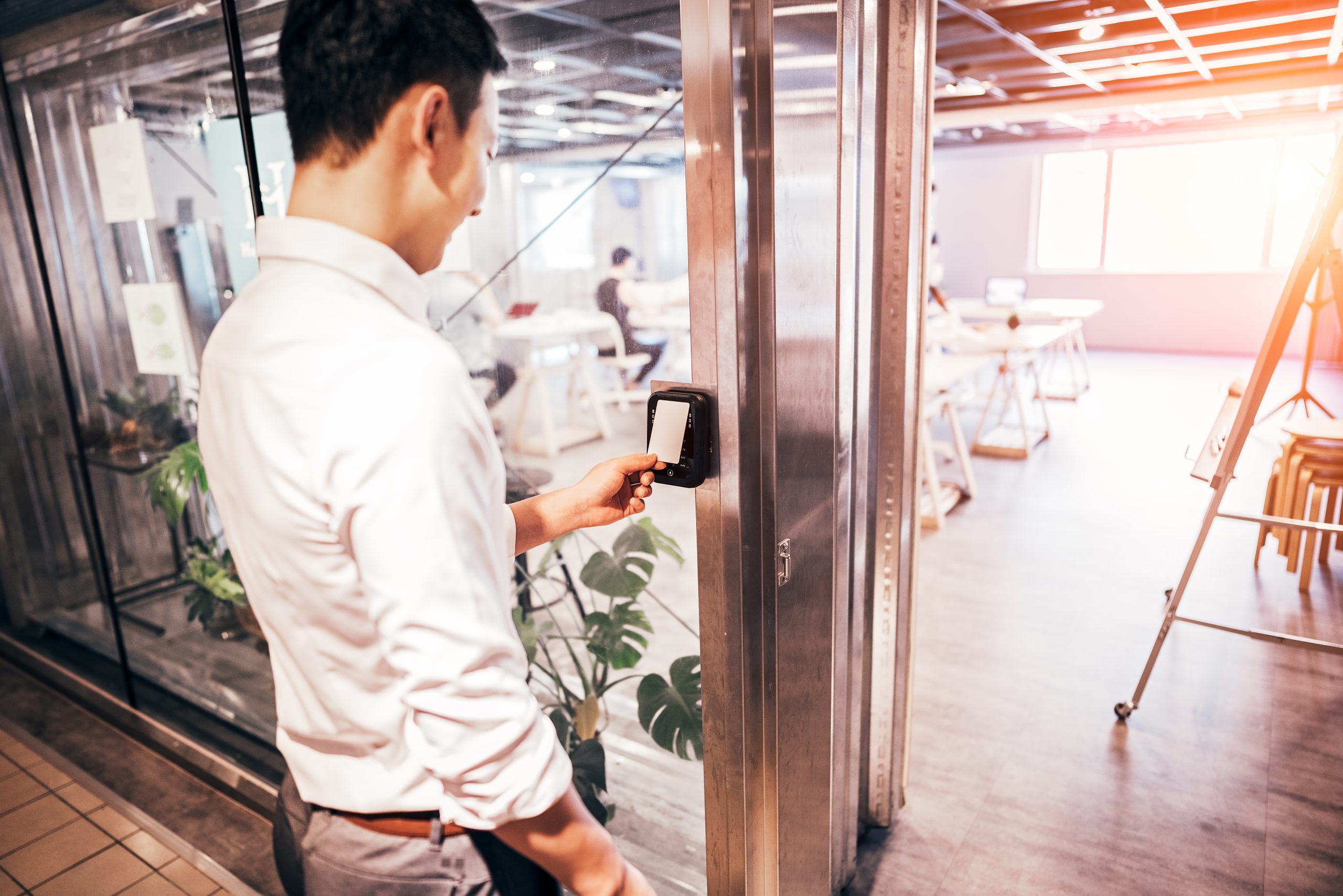 An employee uses an access control system, an essential part of a fully integrated security system.